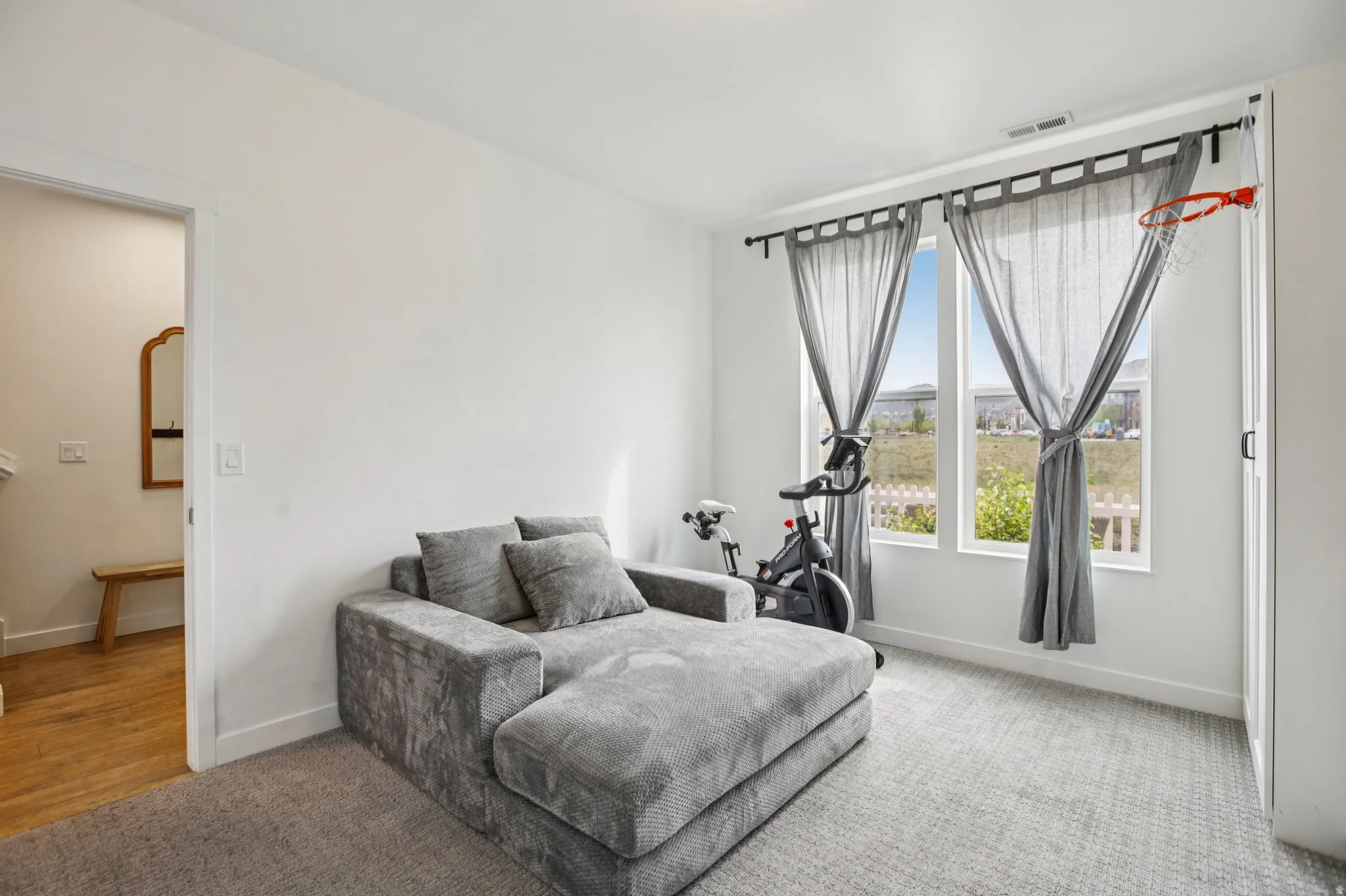 Living area with baseboards and light carpet