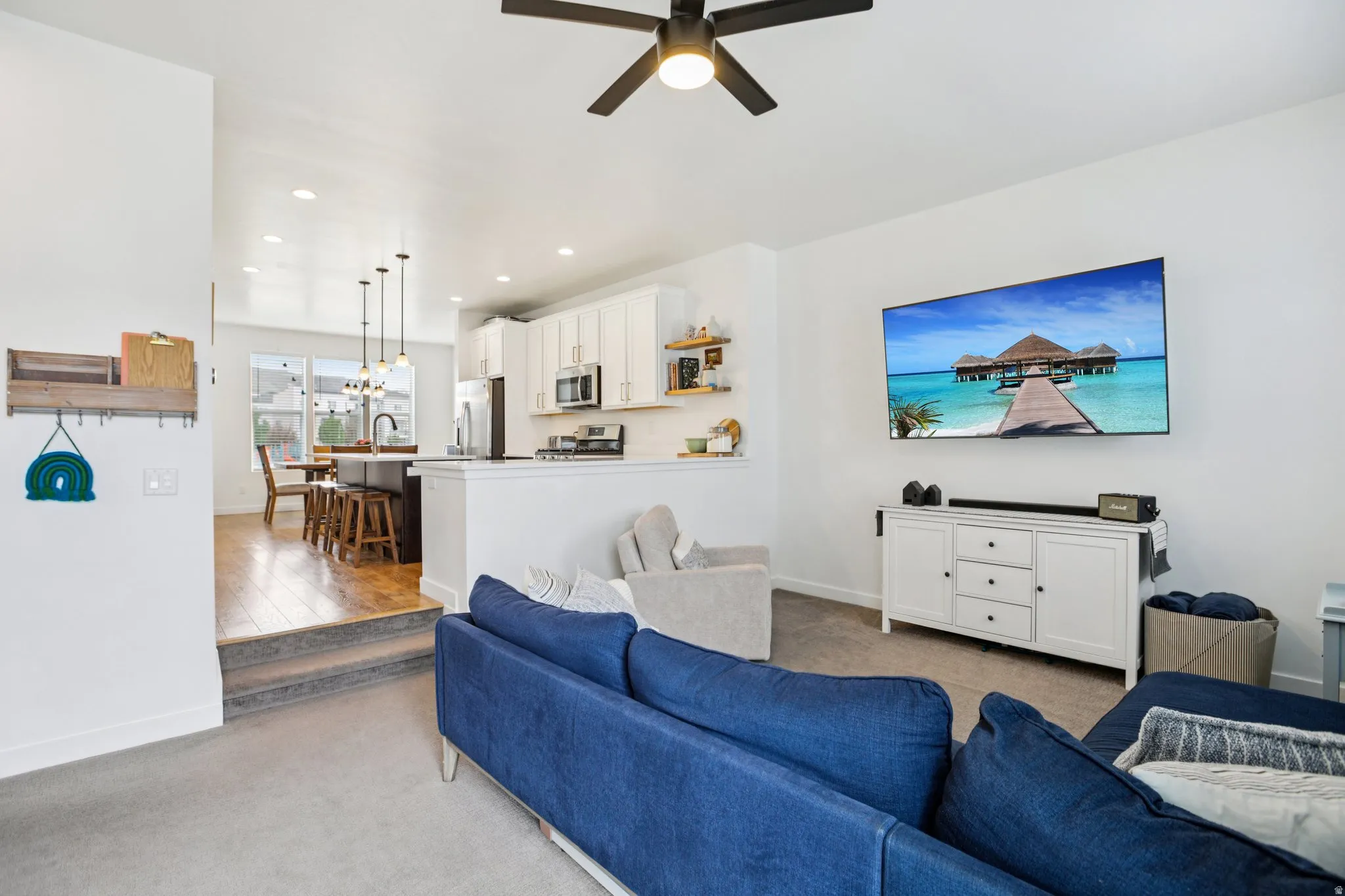 Living room featuring light colored carpet, a ceiling fan, and recessed lighting