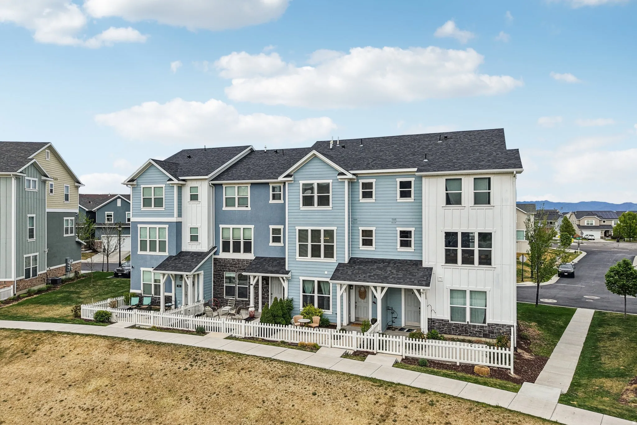 View of front of home featuring board and batten siding, a fenced front yard, a residential view, and roof with shingles