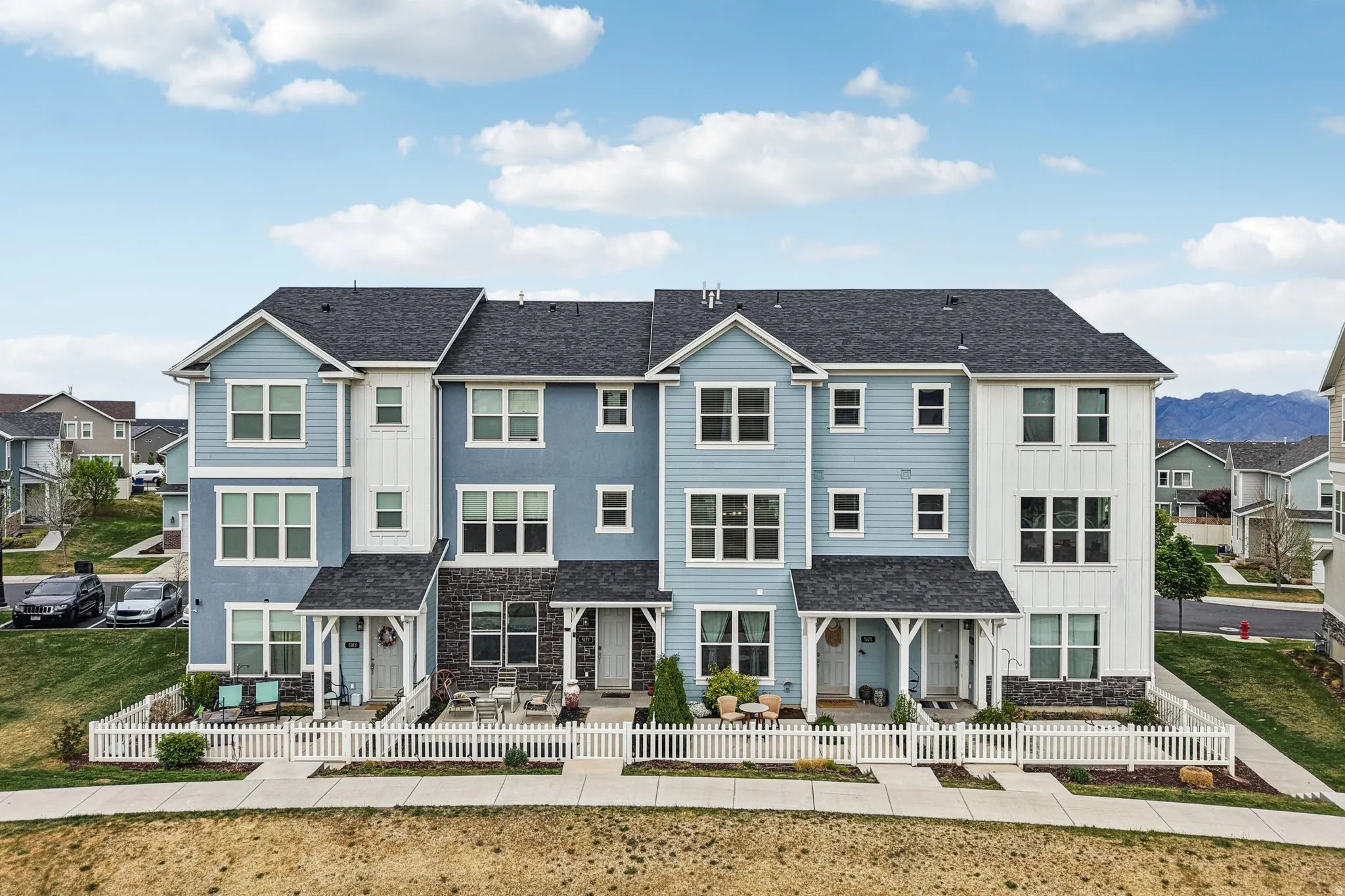 View of front of property with stone siding, a residential view, board and batten siding, and roof with shingles