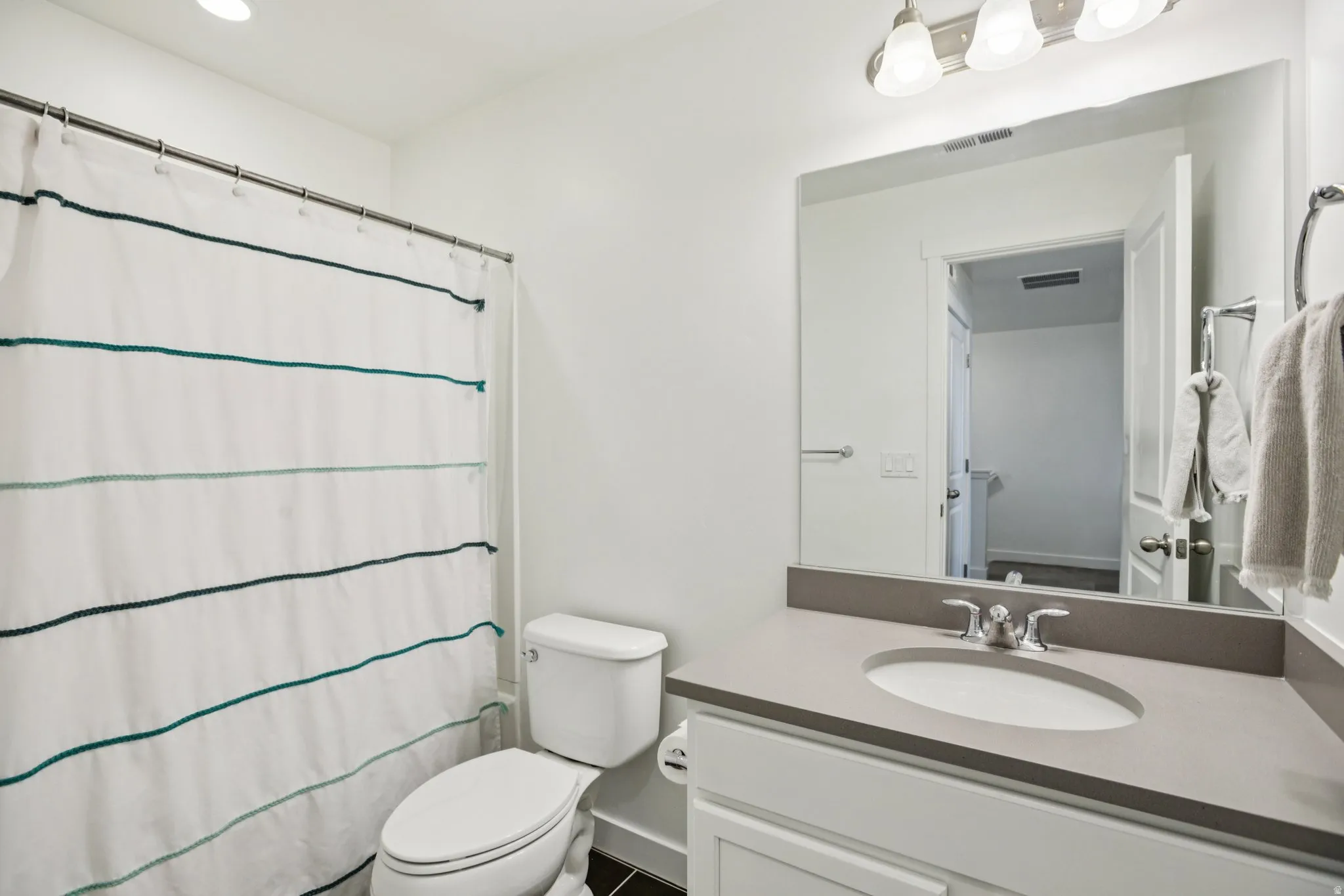 Bathroom with curtained shower and vanity