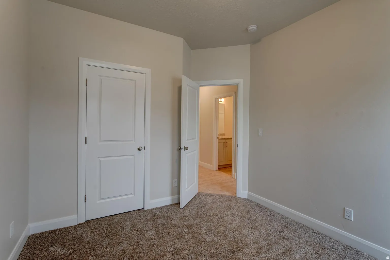 Unfurnished bedroom with baseboards and light colored carpet