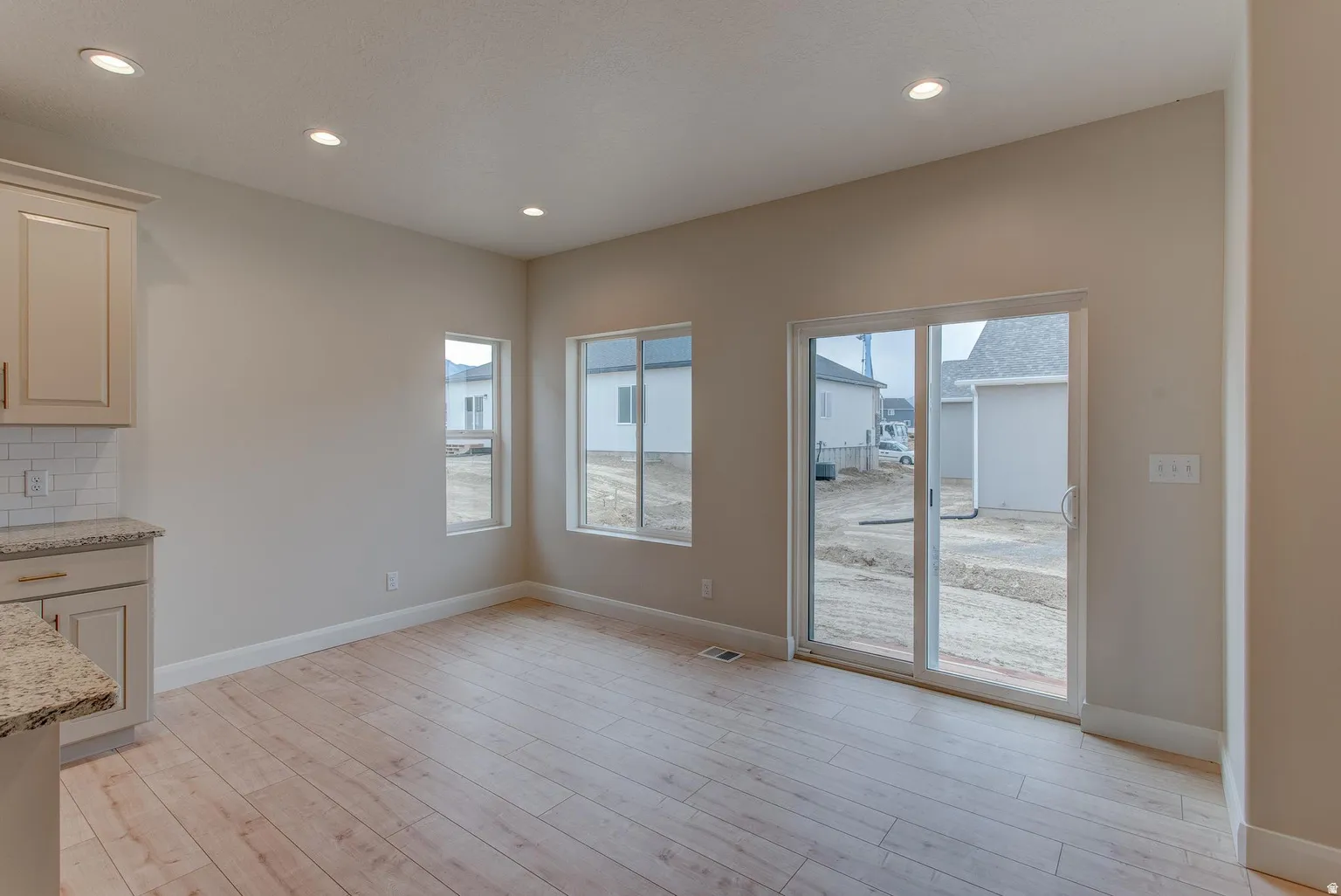 Unfurnished dining area with light wood-style floors, recessed lighting, and healthy amount of natural light
