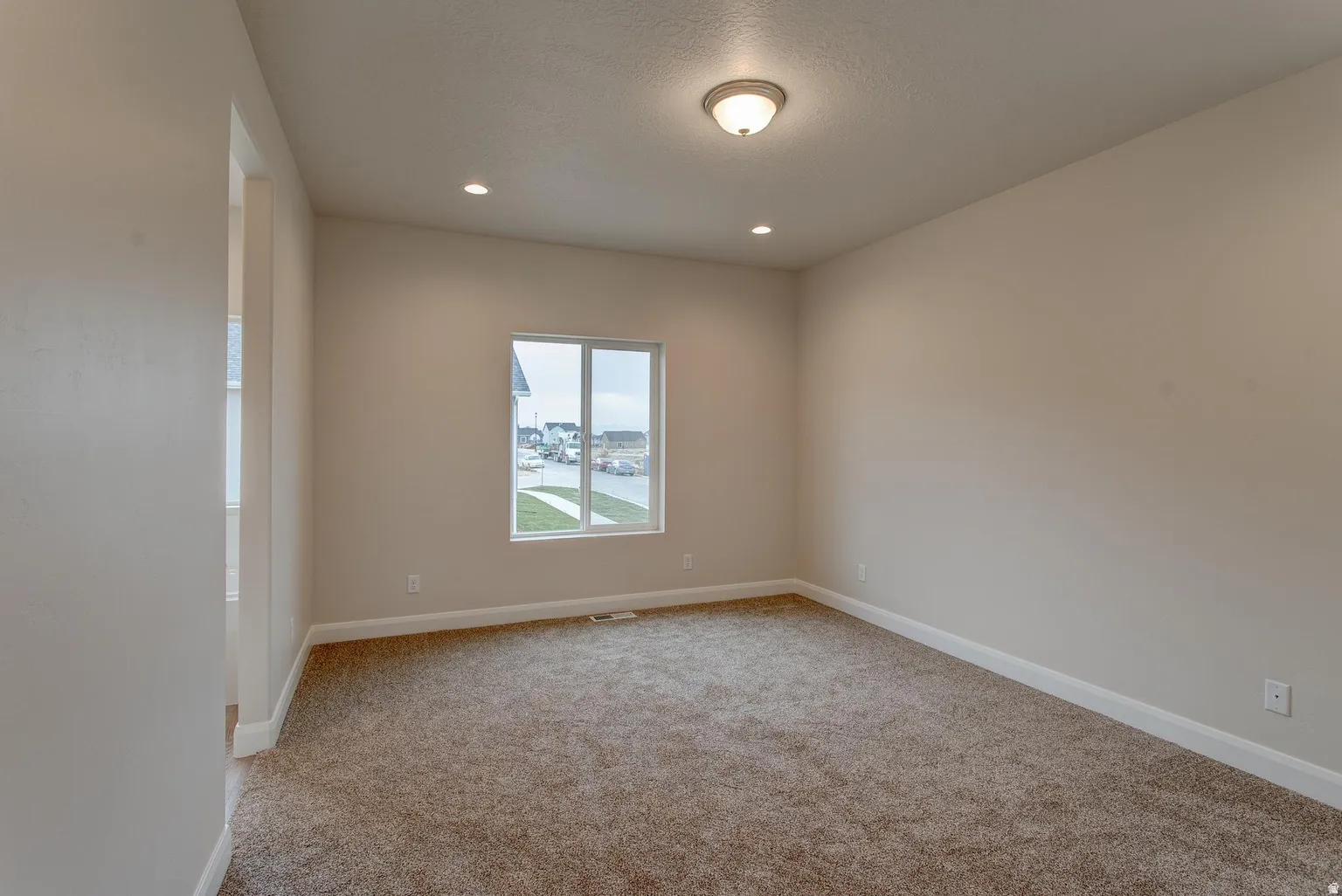 Spare room featuring light carpet and recessed lighting
