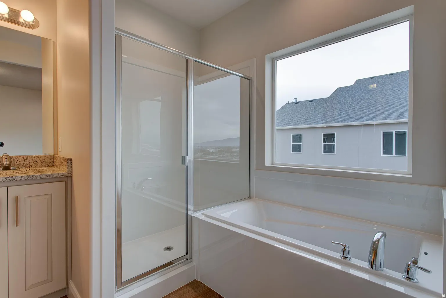 Bathroom with a shower stall, vanity, and a bath