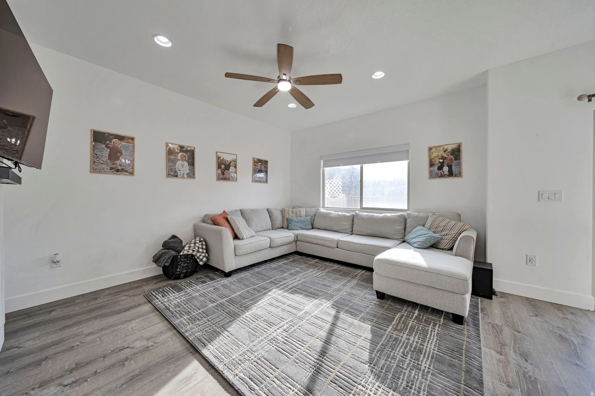 Living room featuring light wood-style flooring, recessed lighting, and a ceiling fan