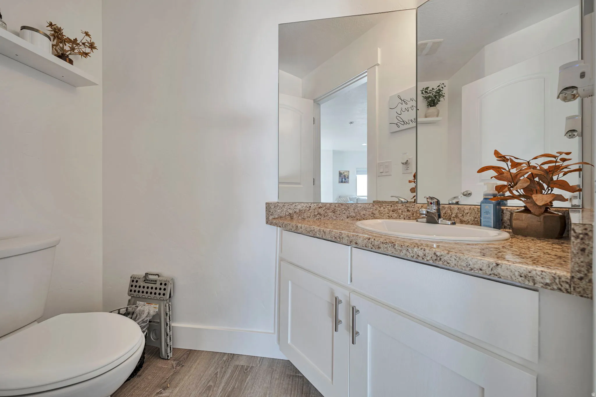 Half bathroom with vanity and light wood finished floors