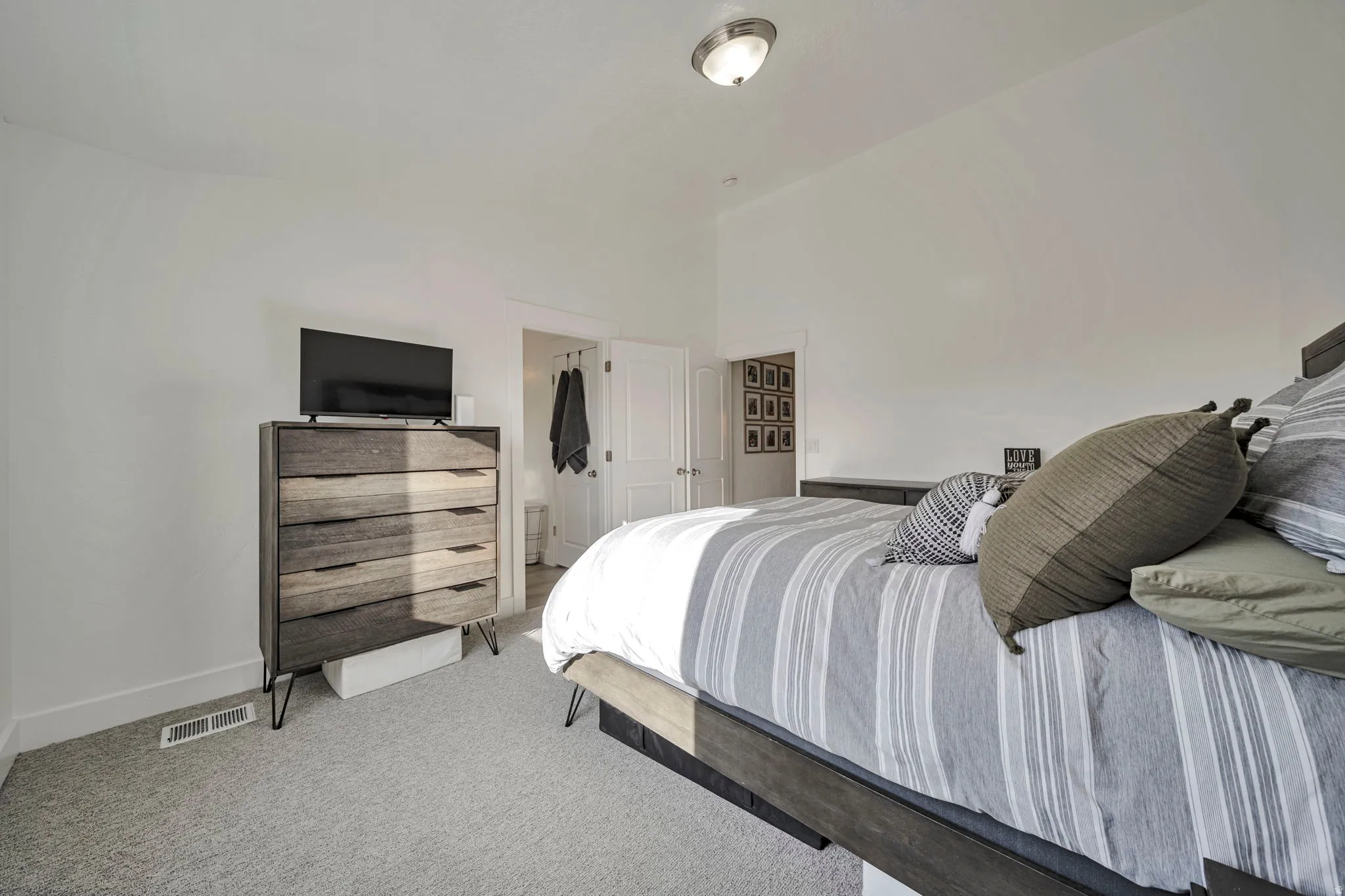 Bedroom with light colored carpet and baseboards
