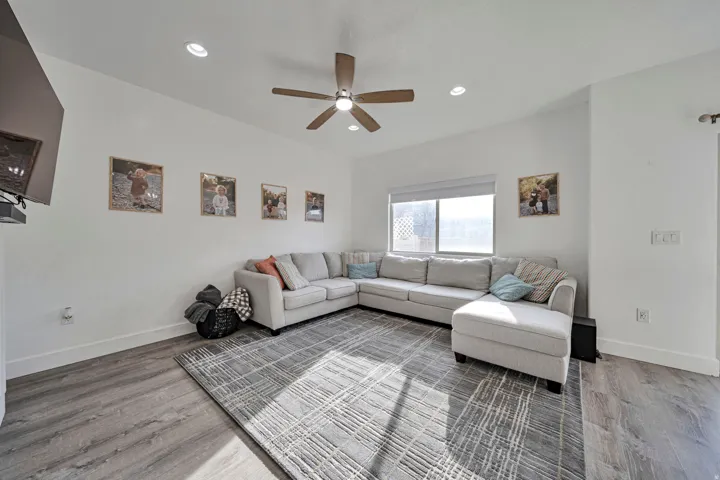 Living room featuring light wood-style flooring, recessed lighting, and a ceiling fan