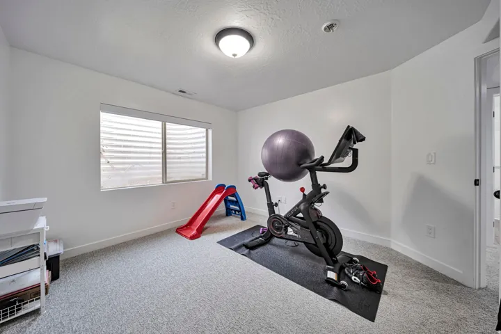 Workout area with a textured ceiling and light colored carpet