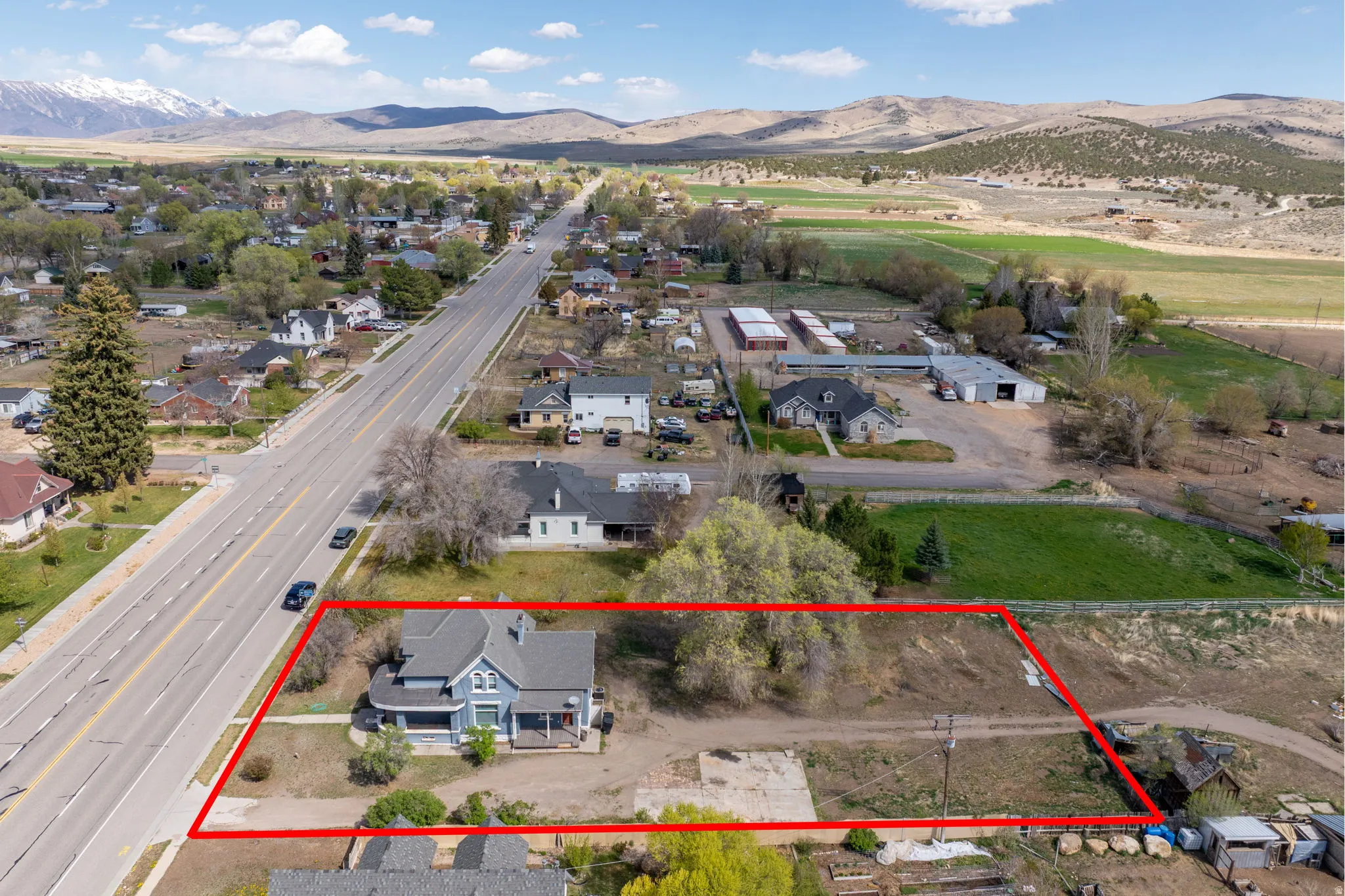Aerial perspective of suburban area featuring a mountainous background and property boundaries highlighted