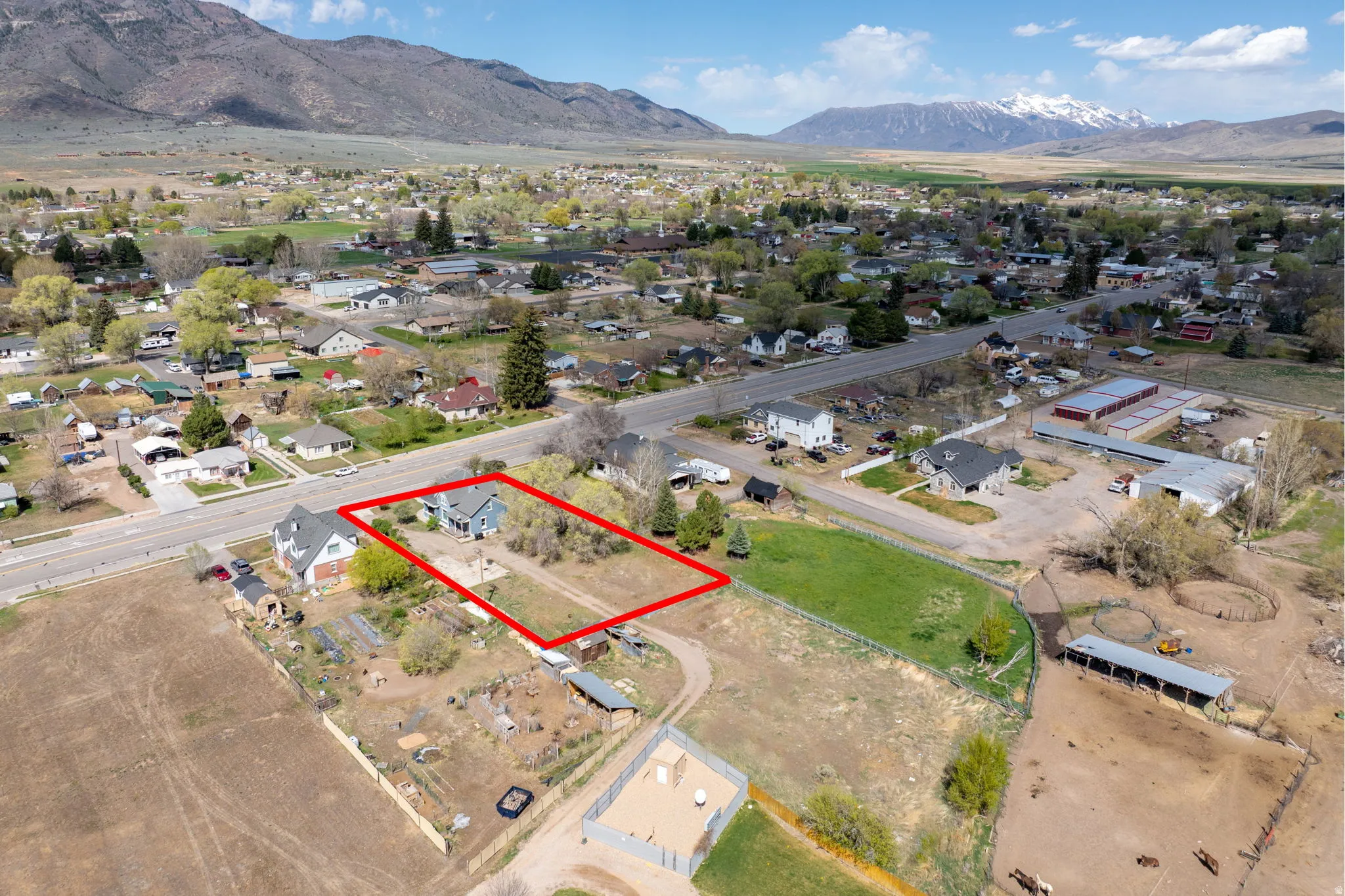 Aerial view of residential area featuring a mountain backdrop and property parcel outlined