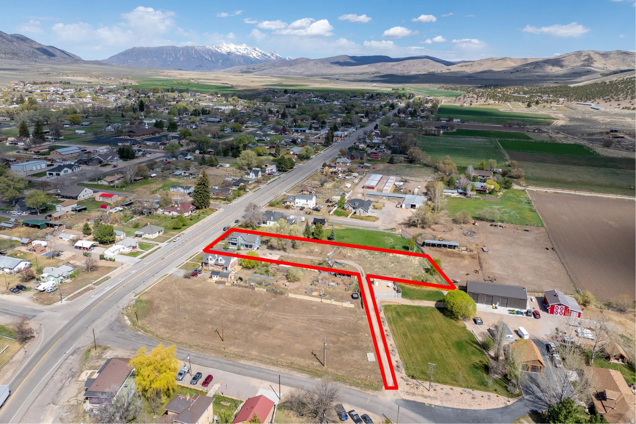 Aerial view of property and surrounding area with property boundaries highlighted and a mountainous background