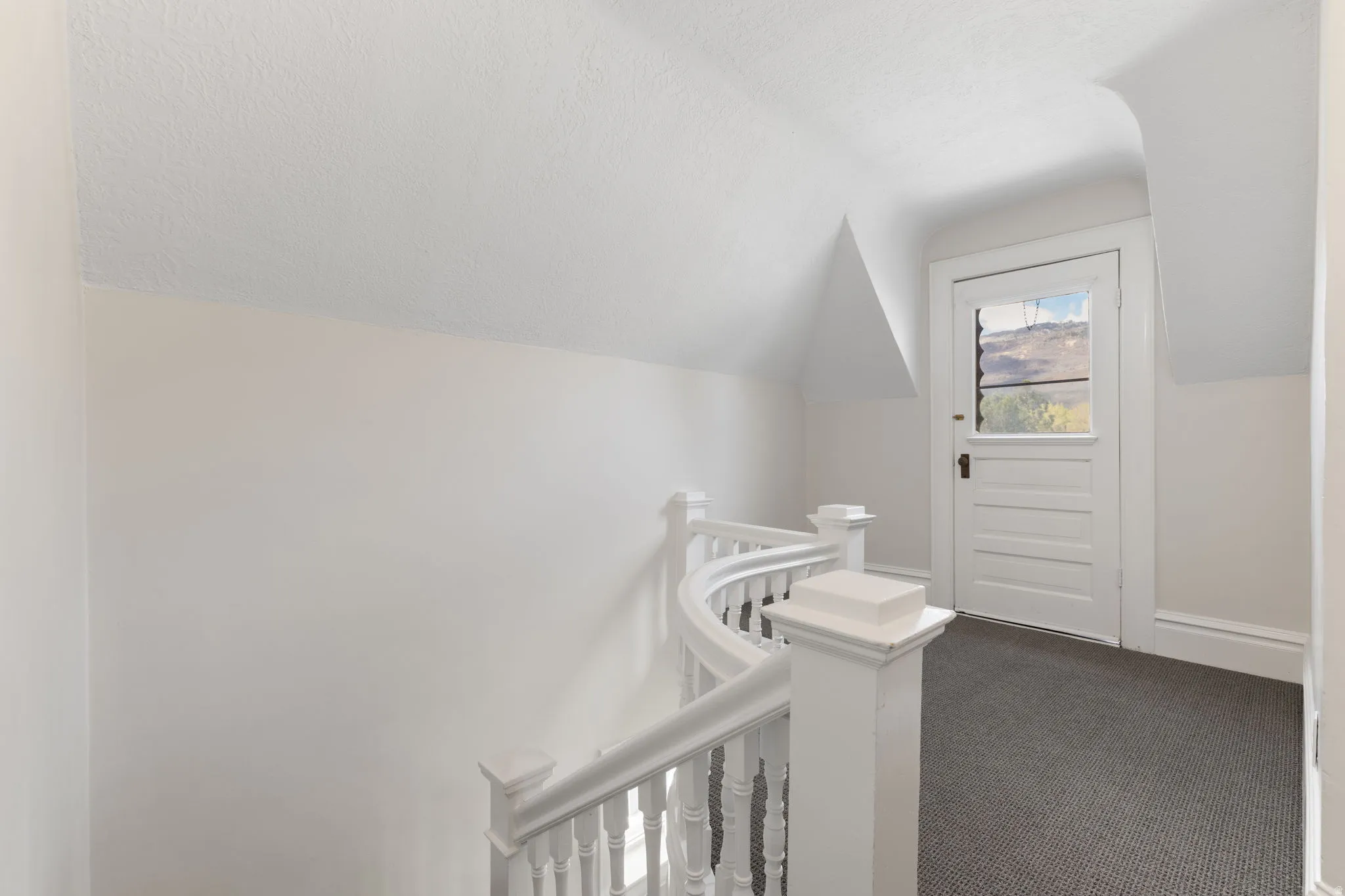 Corridor featuring lofted ceiling, carpet flooring, and an upstairs landing