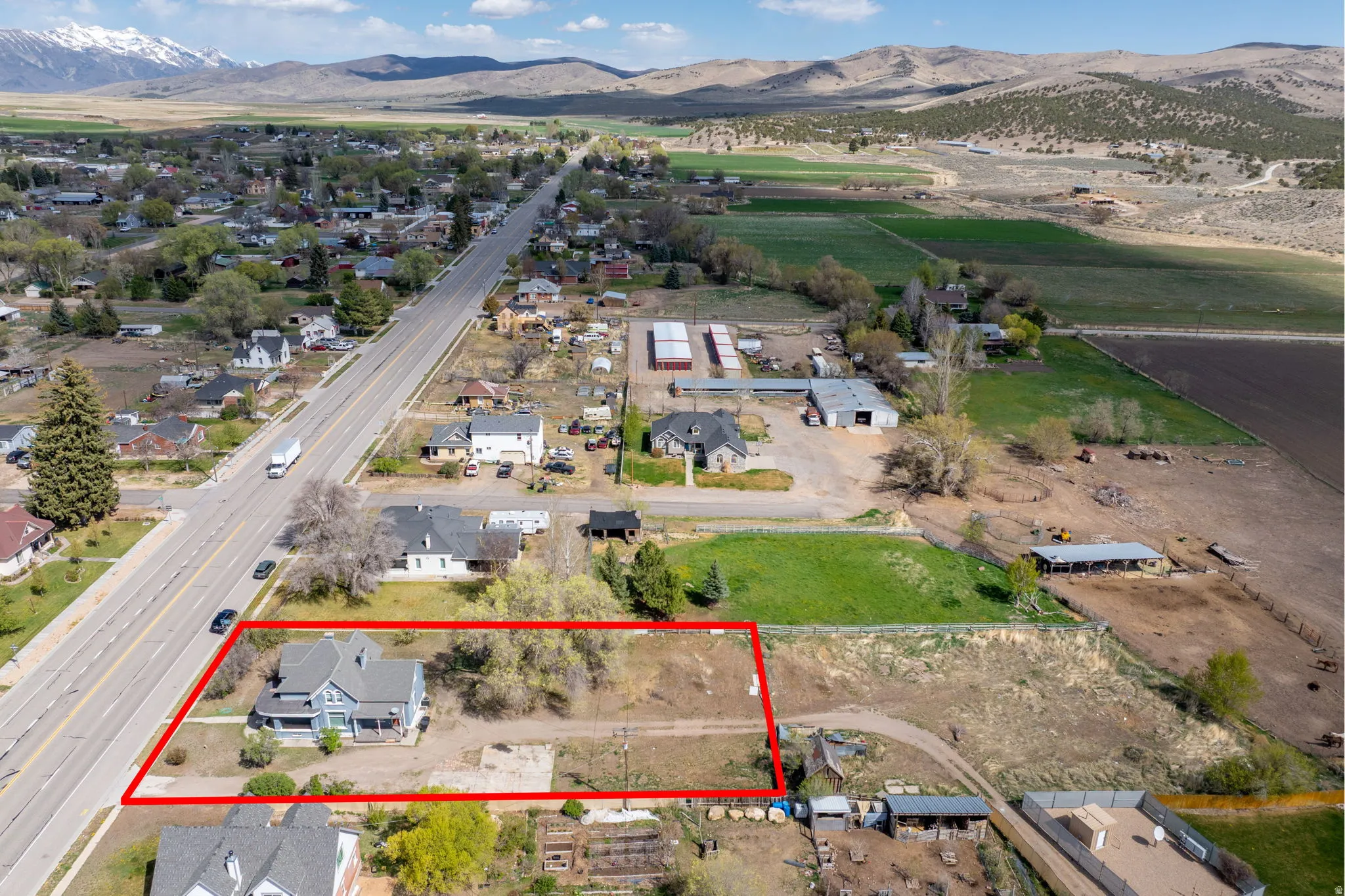 View of rural area with mountains, property boundaries highlighted, and nearby suburban area