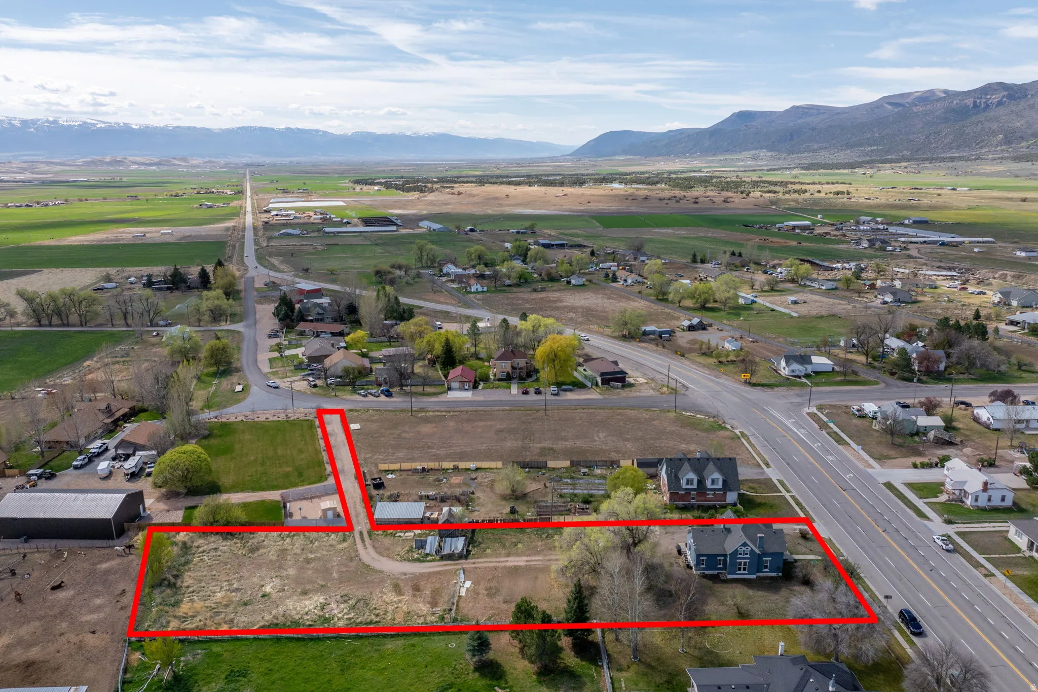 Aerial view of residential area featuring property parcel outlined and mountains