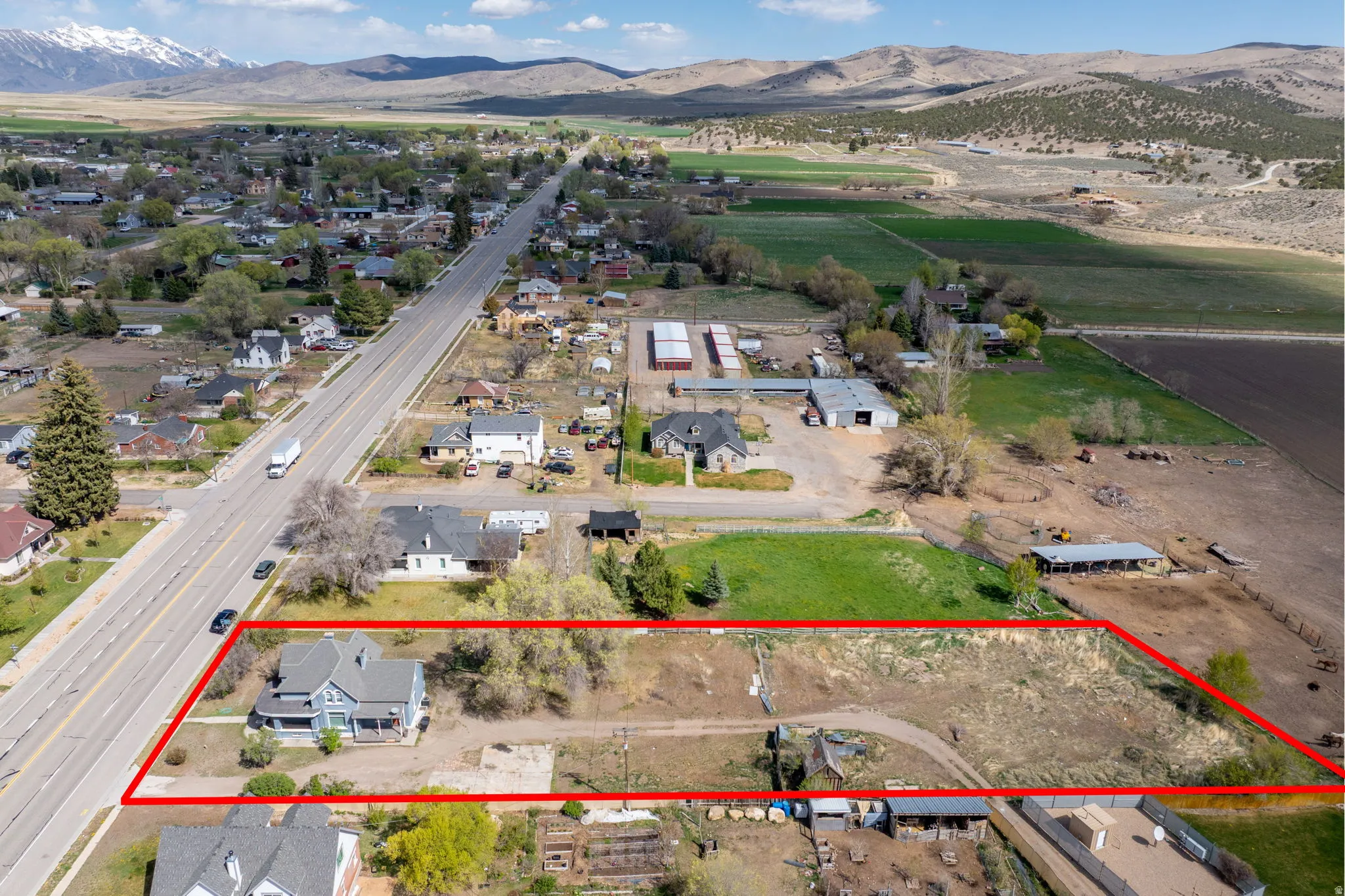 View of rural area with mountains, property boundaries highlighted, and nearby suburban area
