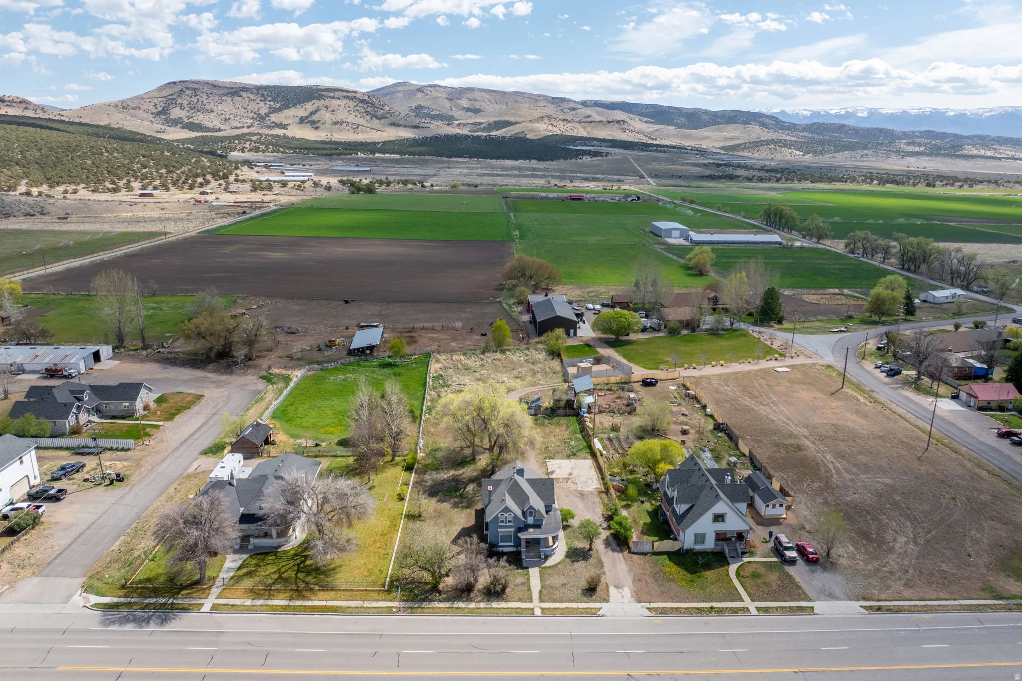 Aerial view of sparsely populated area with a mountainous background and nearby suburban area