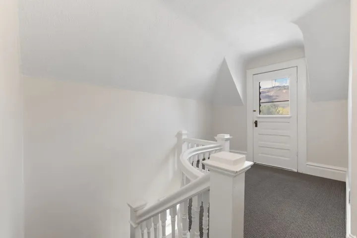 Corridor featuring lofted ceiling, carpet flooring, and an upstairs landing