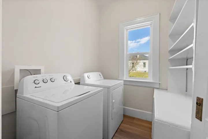 Laundry area with dark wood-style flooring and separate washer and dryer