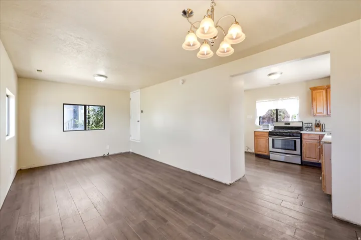 Open-concept living area with wood-finish flooring, recessed lighting, and a decorative chandelier