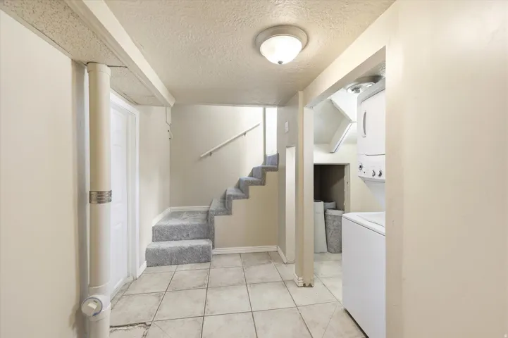 Lower level with tile flooring and carpeted stairs