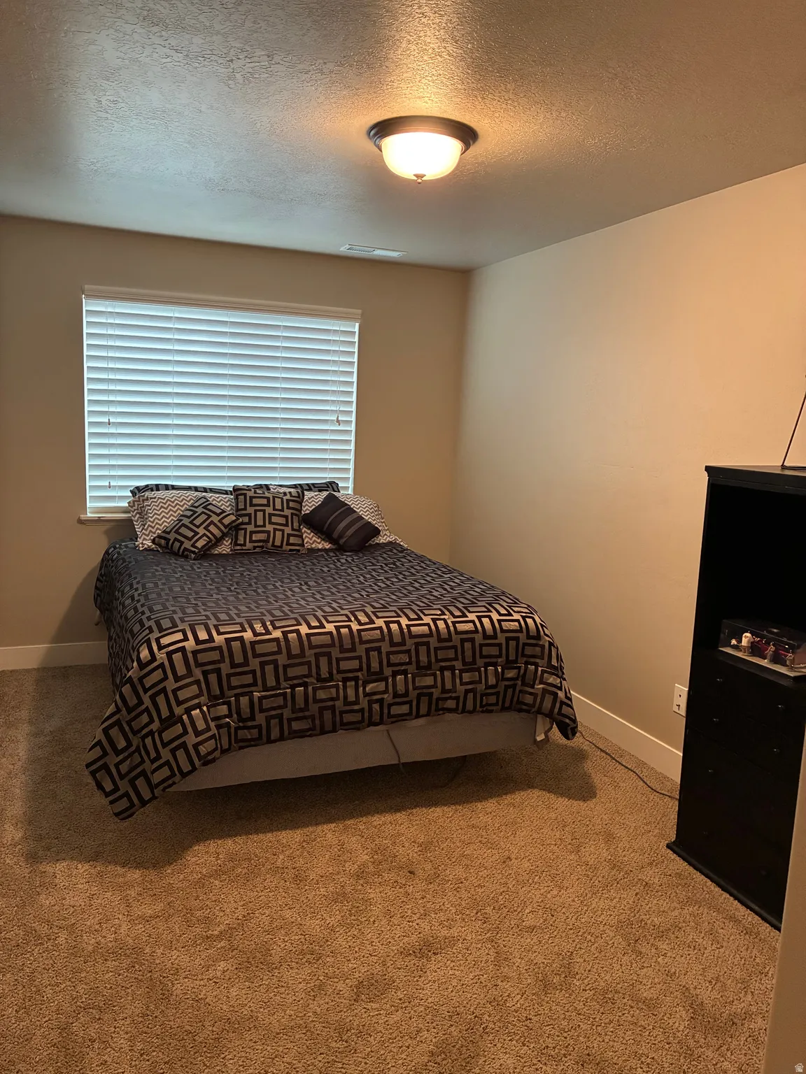Bedroom featuring a textured ceiling and carpet floors