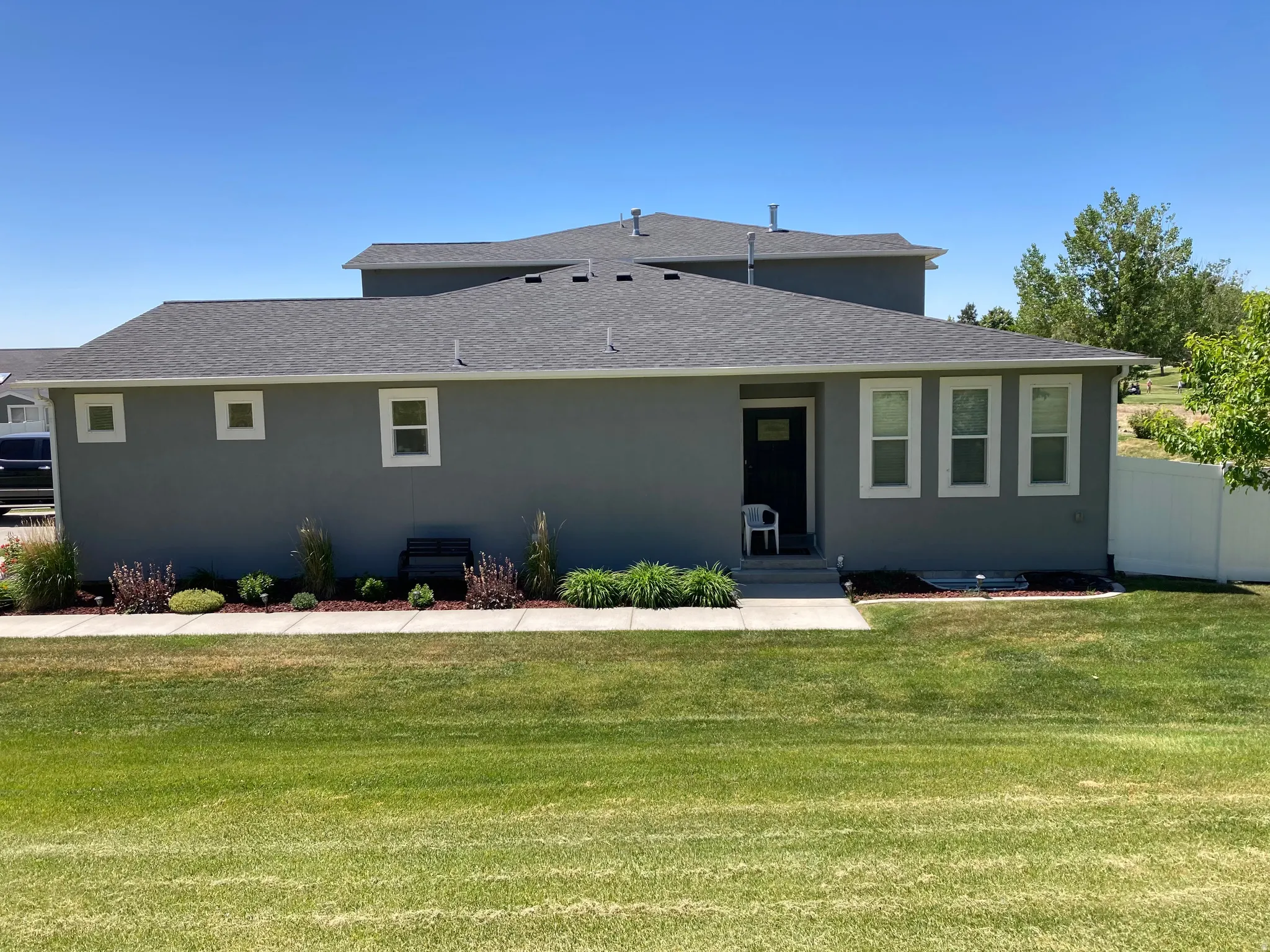 Rear view of property with roof with shingles and stucco siding
