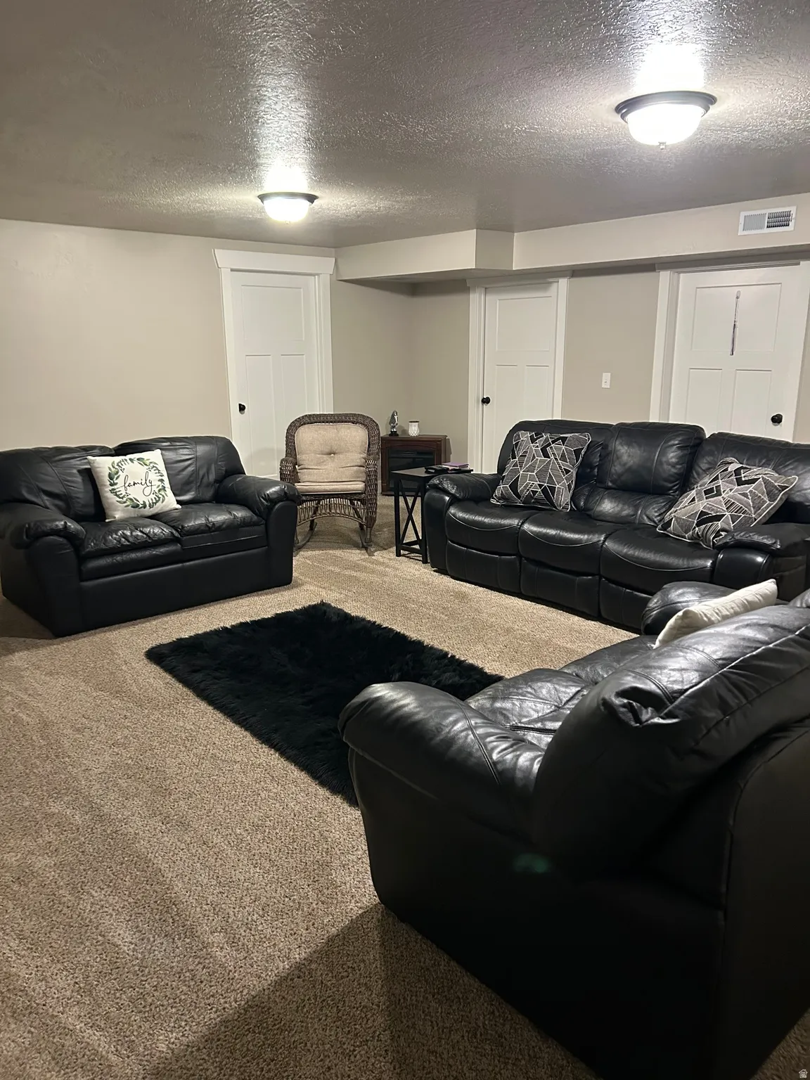Living area with a textured ceiling and carpet floors