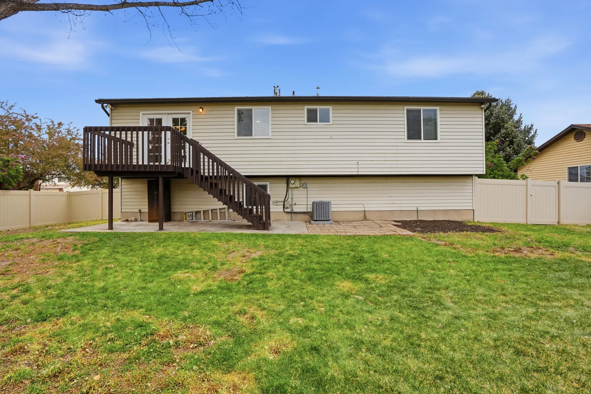 Rear view of house featuring a patio area, a fenced backyard, a gate, and a deck