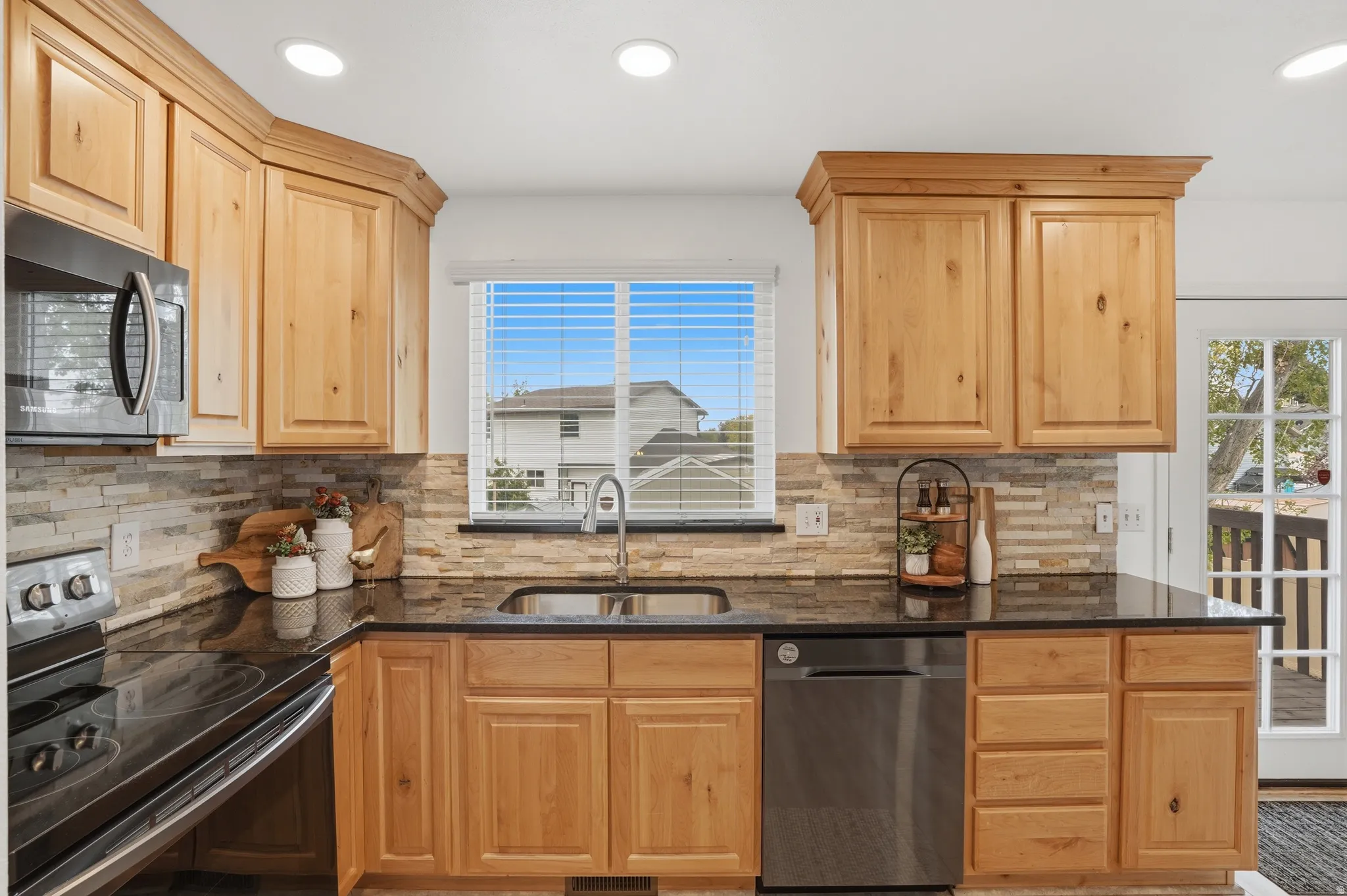 Kitchen featuring stainless steel electric range, dishwasher, dark stone countertops, recessed lighting, and light wood finish cabinetry
