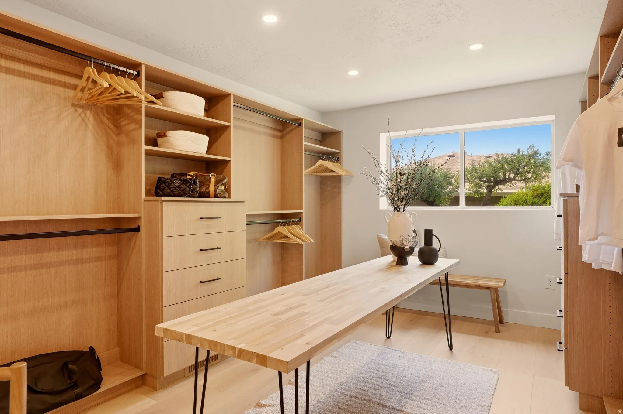 EXQUISITE PRIMARY CLOSET WITH CUSTOM BUILT-INS AND ROOM FOR MASSAGE OR FOLDING TABLE