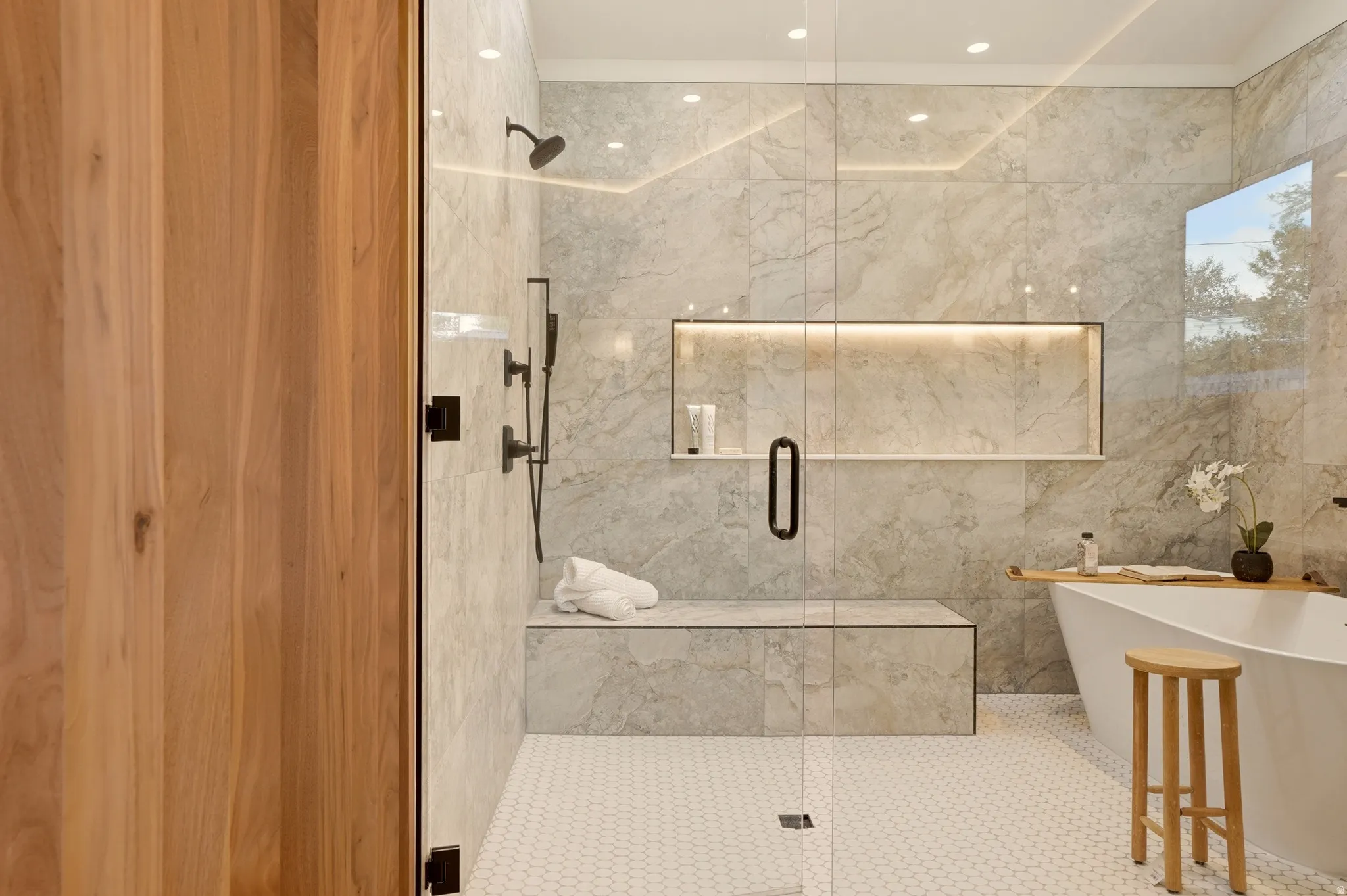 Bathroom with a freestanding bath, a marble finish shower, recessed lighting, and tile walls