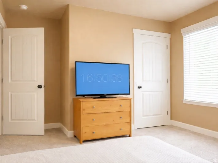 Bedroom featuring light colored carpet and baseboards