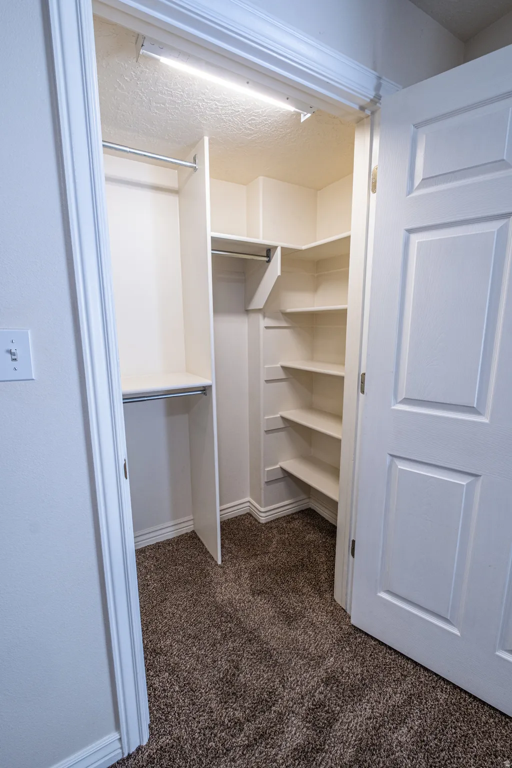 Walk in closet featuring dark carpet