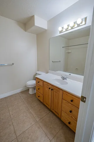 Bathroom featuring vanity, a textured ceiling, light tile patterned floors, and a shower