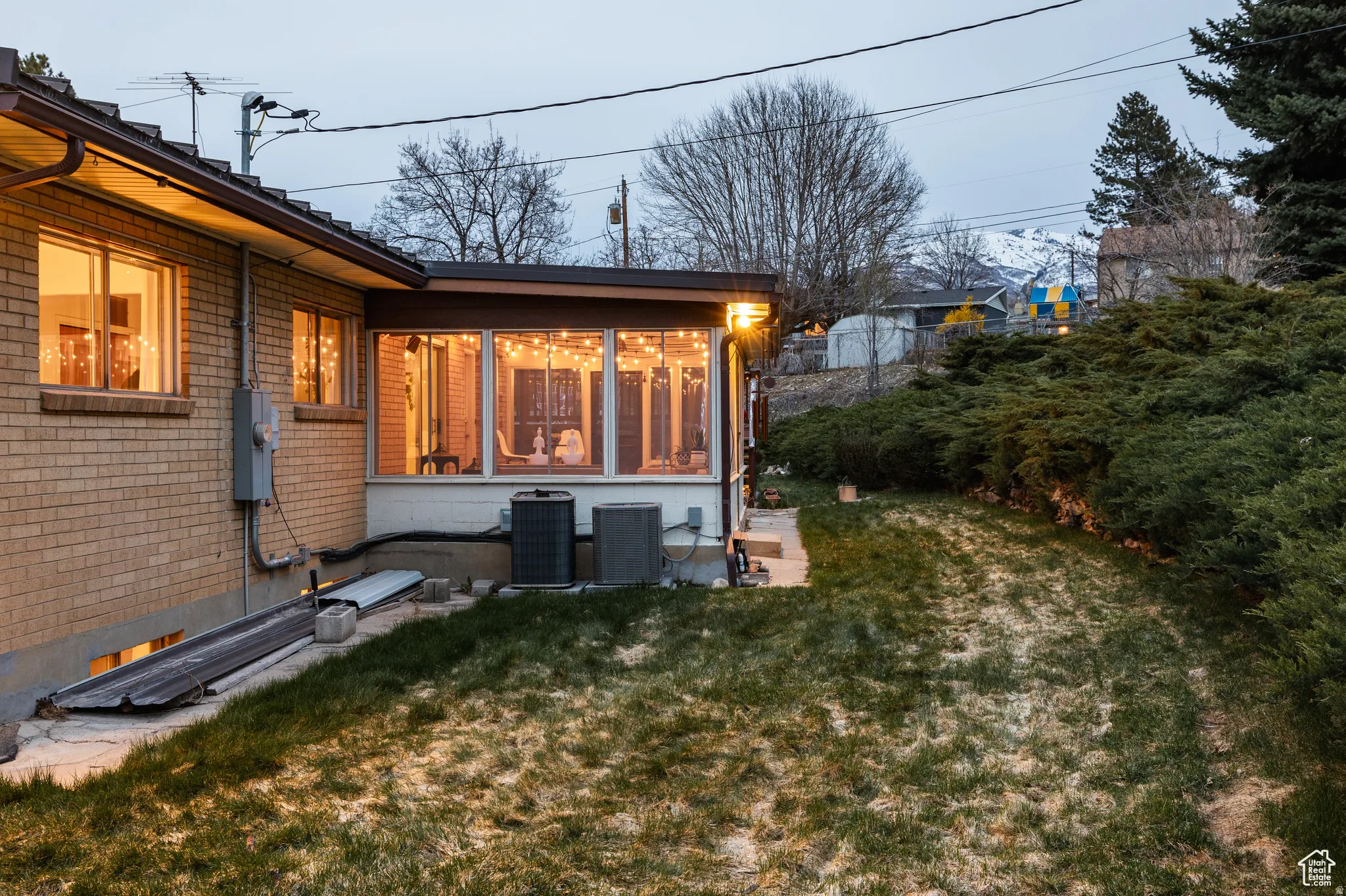 Back of property featuring a yard, a sunroom, and brick siding