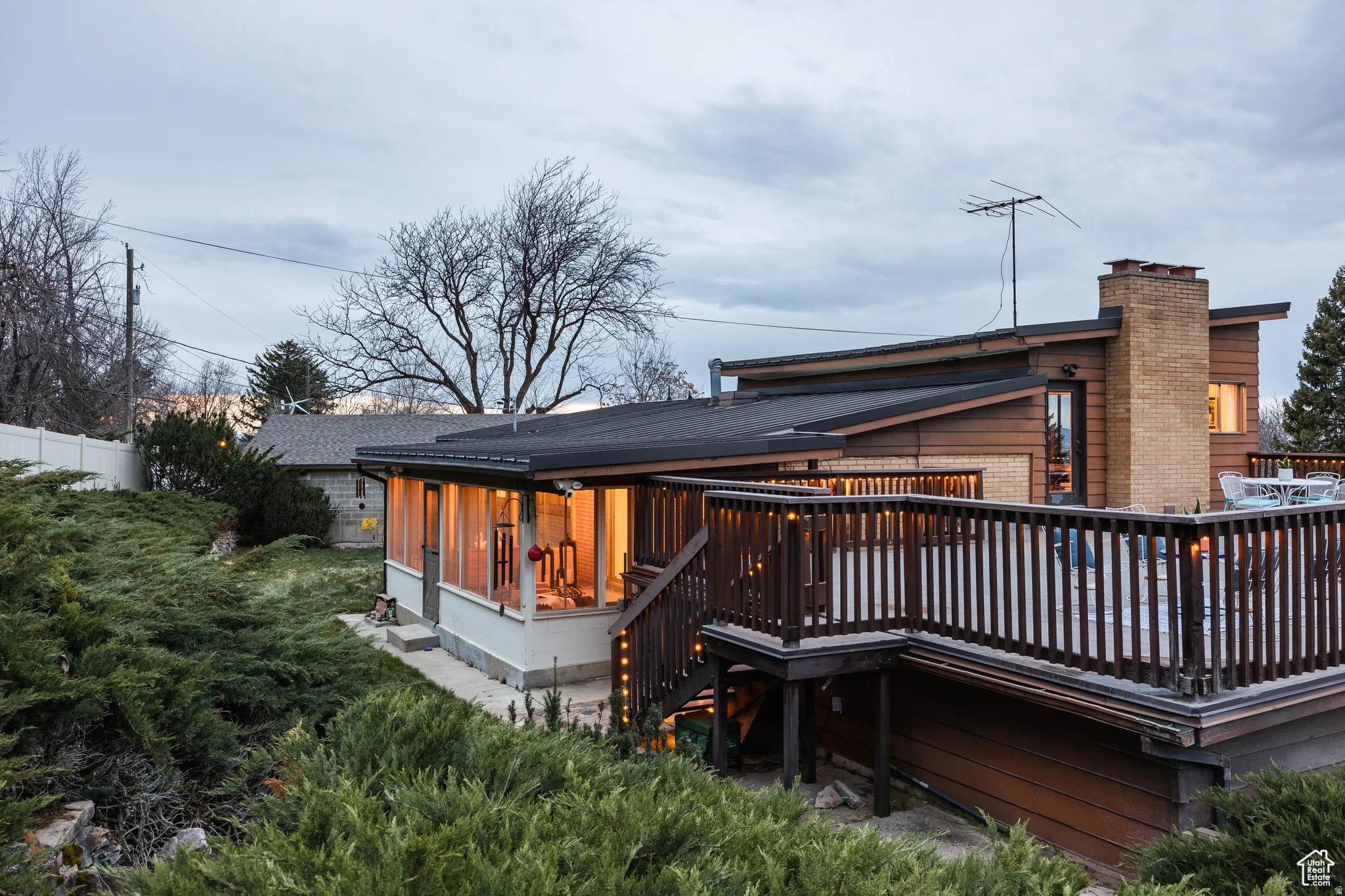 Rear view of house with a chimney, a deck, and brick siding