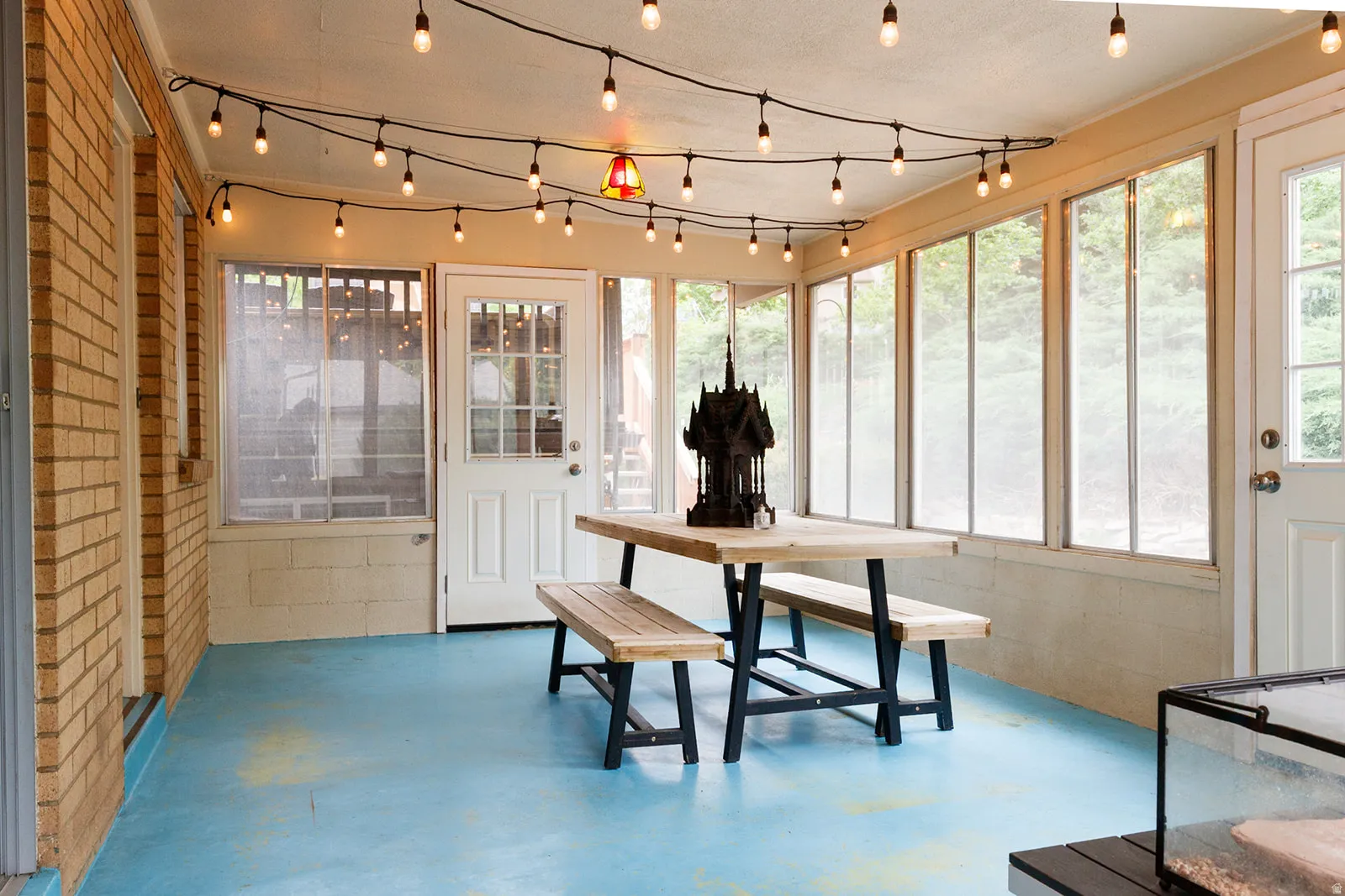 Sunroom / solarium featuring concrete flooring, brick wall, and concrete block wall