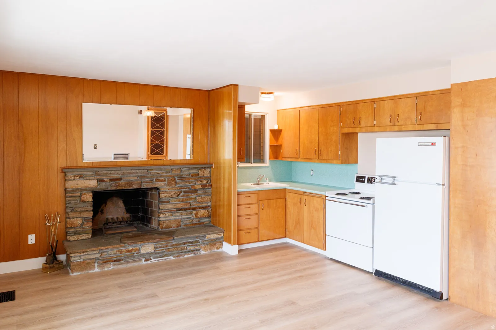 Kitchen with white appliances, light countertops, light wood-style floors, a fireplace, and open shelves