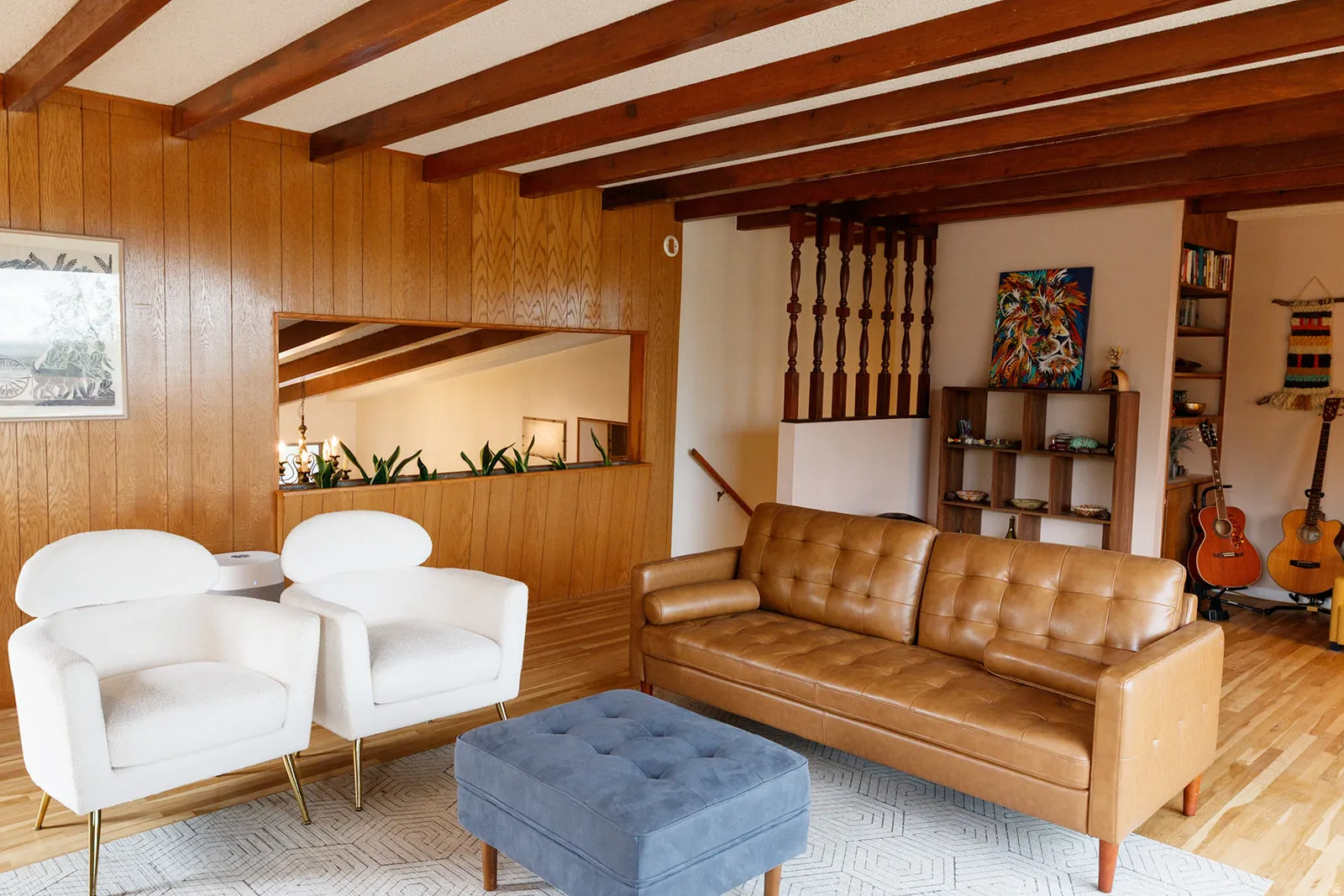 Living room featuring light wood-style flooring, wood walls, and beamed ceiling
