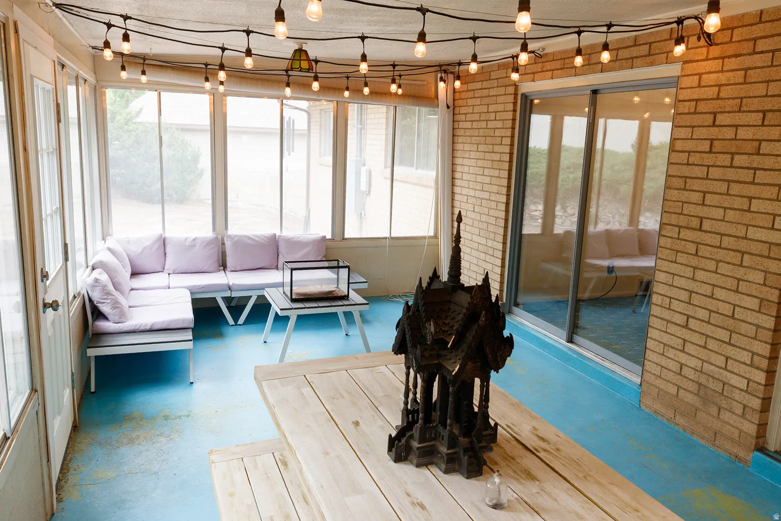 Sunroom / solarium featuring concrete floors and brick wall