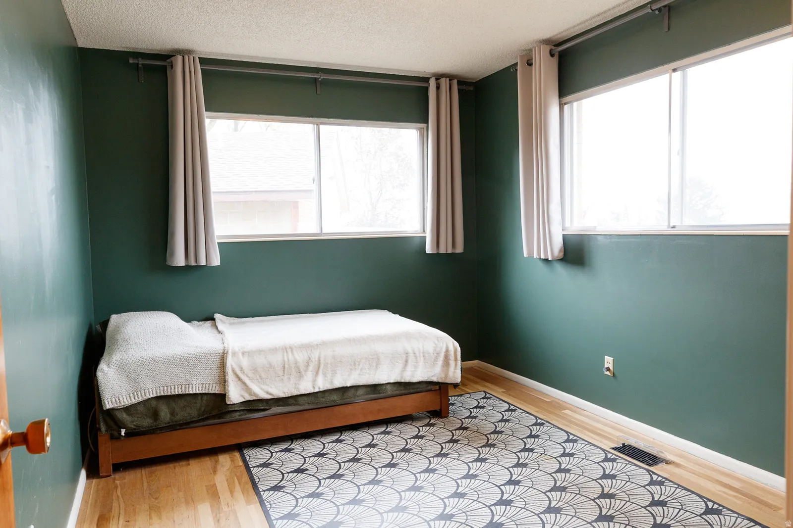 Bedroom with light wood-type flooring and a textured ceiling