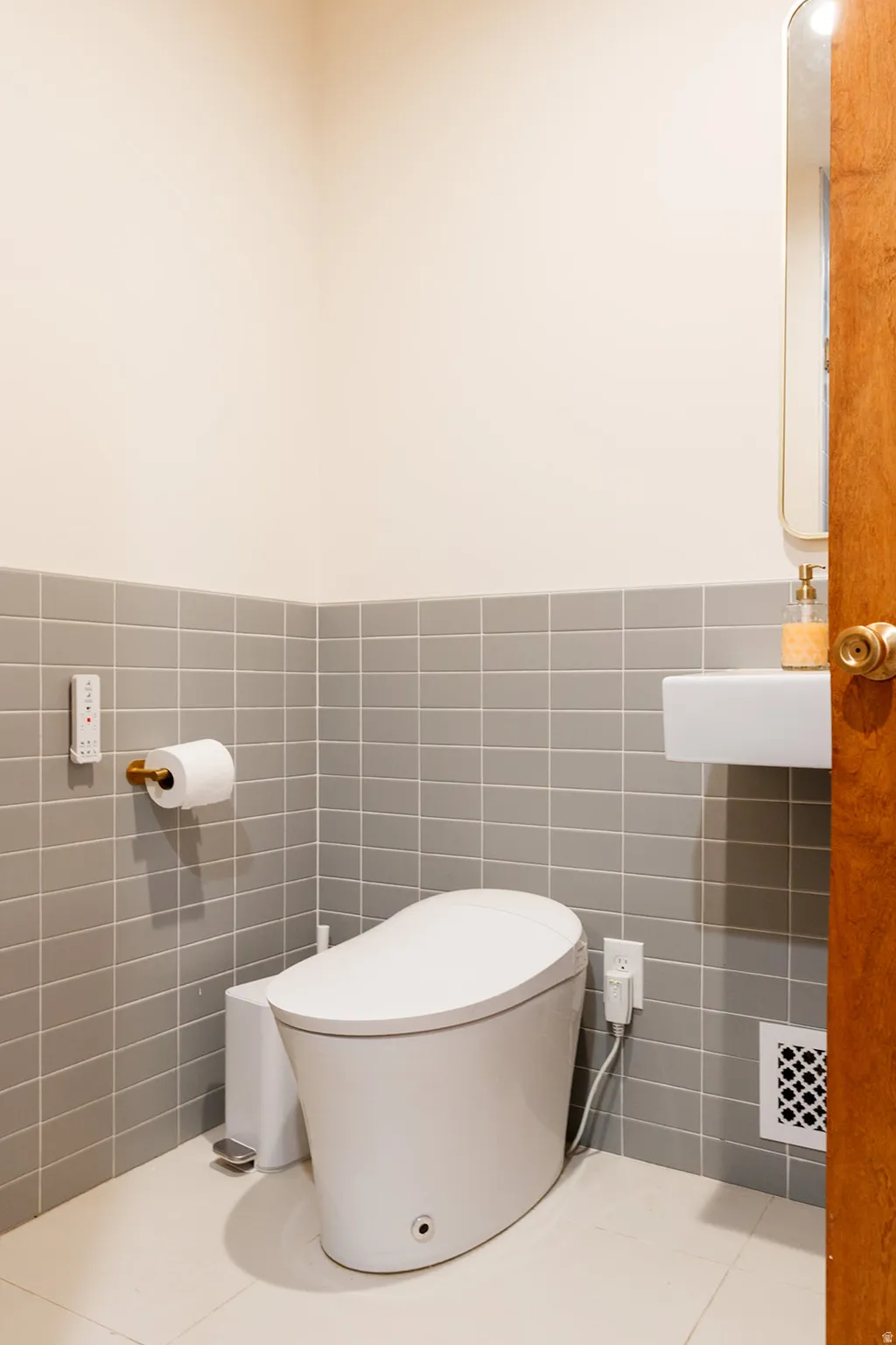 Half bathroom with tile walls and a wainscoted wall