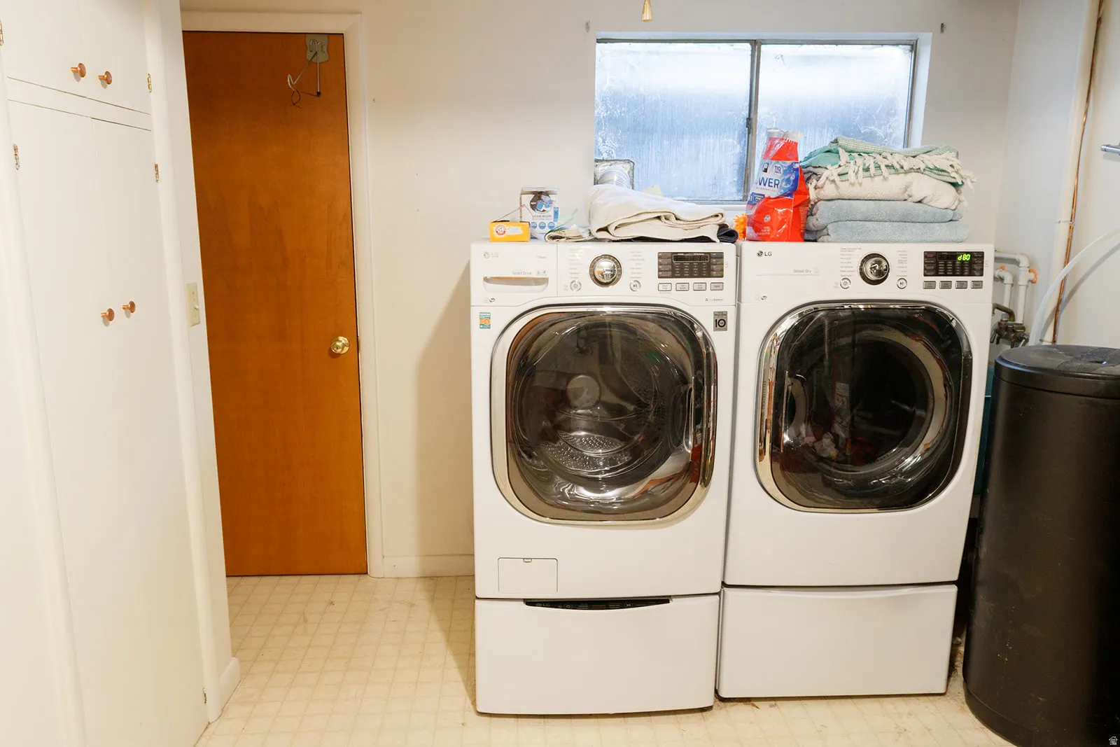 Laundry area featuring light floors and independent washer and dryer