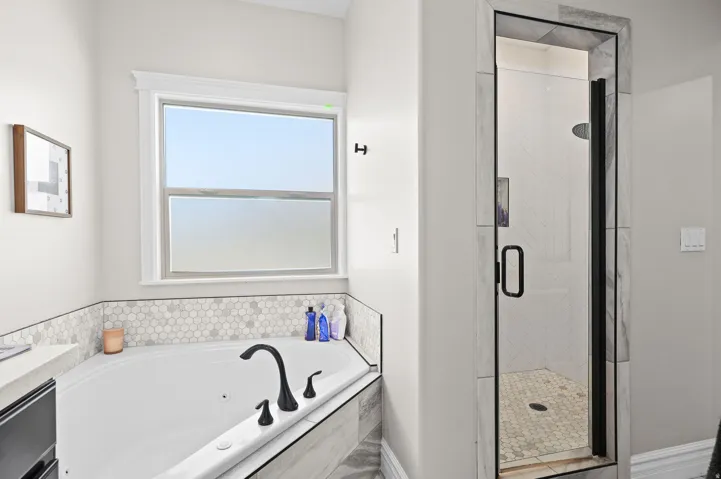 Full bath featuring a stall shower, a whirlpool tub, and vanity