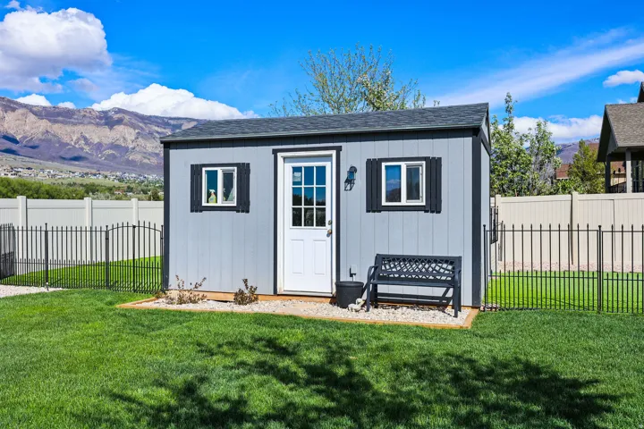 View of outdoor structure with a mountain view and a fenced backyard