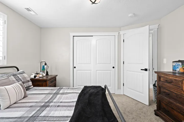 Bedroom featuring a closet, light carpet, and a textured ceiling