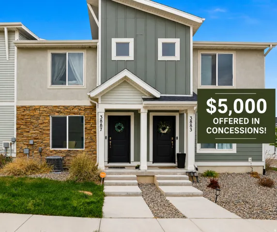 Modern townhome exterior featuring a split facade with stone veneer, stucco, and vertical siding