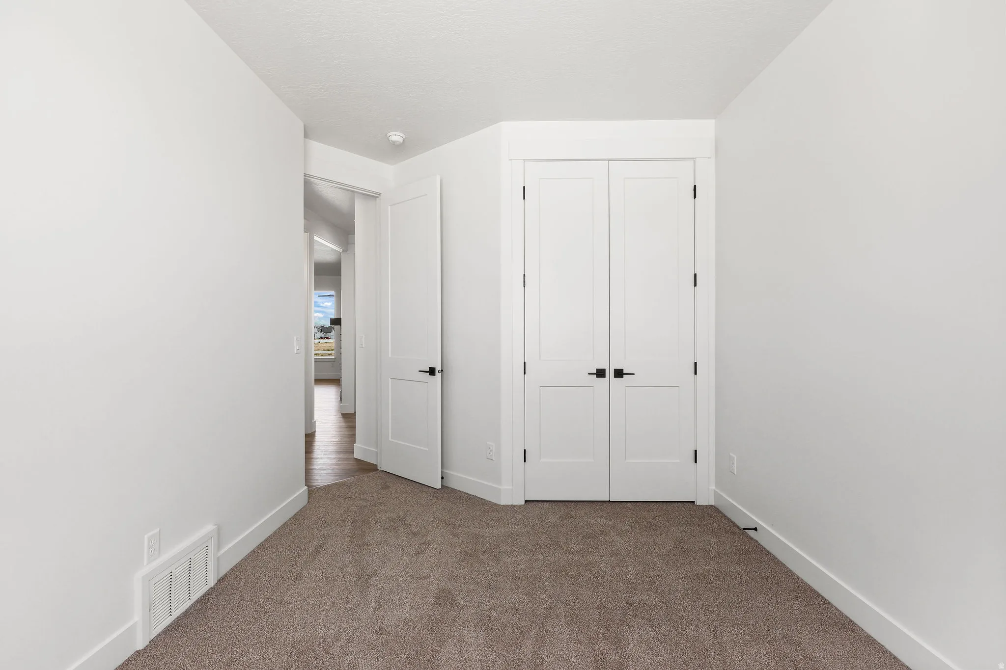 Unfurnished bedroom with dark carpet and a closet